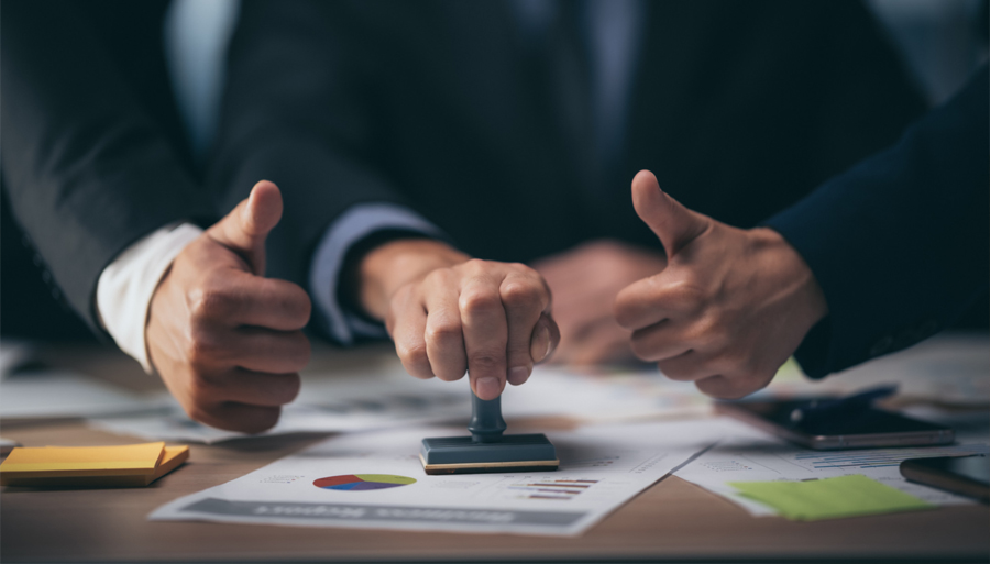 People in suits displaying a rubber stamp for Energy Savings Certificates (ESCs)